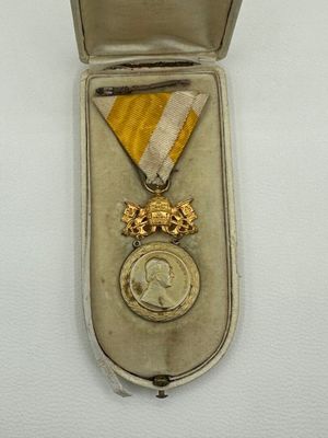 une image représentant une médaille dans un écrin posé sur une surface blanche