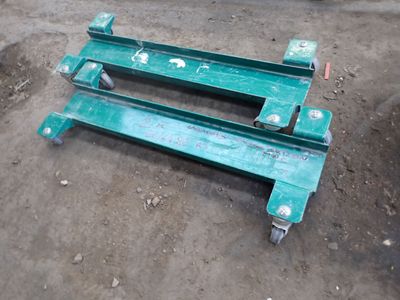 a green bench that is on the ground in the dirt