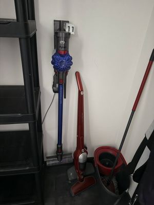 un aspirateur et une serpillière dans un coin de la pièce