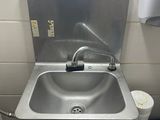 un lavabo dans un coin d'une petite salle de bains