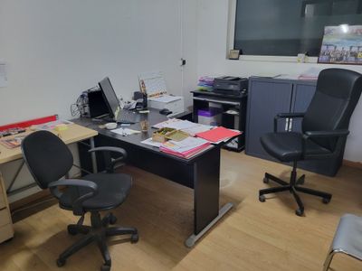 a desk with two chairs and a computer on it