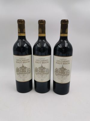 trois bouteilles de vin posées sur une table blanche
