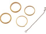 four gold rings and a chain on a white surface