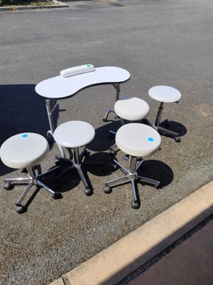 quatre tabourets et une table au milieu d'un parking