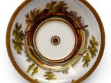 a plate with a picture of a forest scene on it