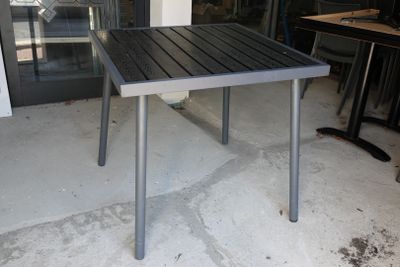 une petite table installée à l'extérieur d'un bâtiment