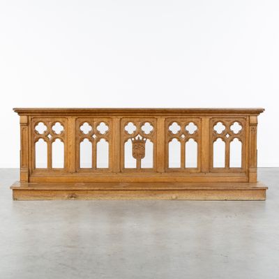 une image représentant un banc en bois surmonté de fenêtres cintrées
