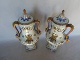 pair of blue and white vases with handles on a white surface