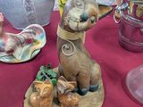 a table with a vase and a figurine of a dog on it