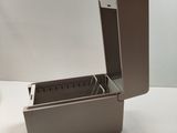 a small metal box with a lid on a white table