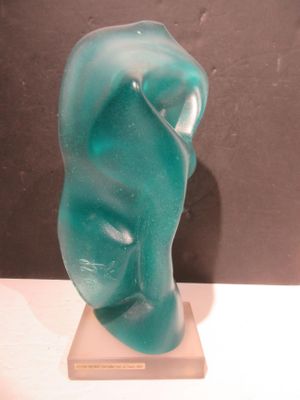 une sculpture en verre représentant le visage d'une femme, posée sur un socle