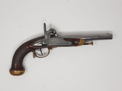 un vieux pistolet avec une poignée en bois sur une surface blanche