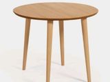une petite table ronde aux pieds en bois sur fond blanc