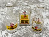 trois bouteilles en verre vides posées sur une surface en béton