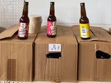 trois bouteilles de bière sont posées sur des cartons dans une pièce