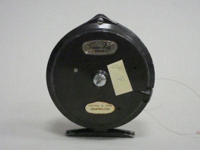 a black reel with a yellow tag on it