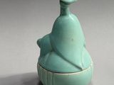 a small blue vase with a bird on it