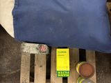 un sac bleu posé sur une palette, à côté d'une bouteille de bière