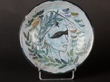 a plate with a woman ' s face painted on it