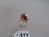une image d'une bague avec une pierre rouge entourée de diamants blancs