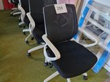 Plusieurs chaises de bureau sont alignées en rang dans une pièce