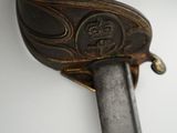 a close up of a sword on a white surface