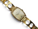 a close up of a gold wrist watch on a white surface