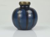 a small blue vase with a gold top on a white surface