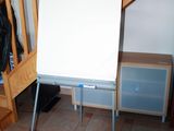 a white board on a stand in the corner of a room