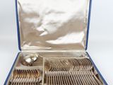 un service en argent dans un coffret bleu contenant une cuillère en argent et un repose-cuillère