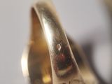 a close up of a gold ring with a diamond on it
