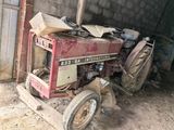 a red tractor that is parked in a garage