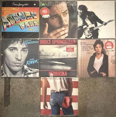 many different album covers on the wall of a room