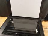 a black printer sitting on top of a wooden table next to a black wall