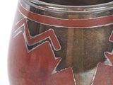 a red vase with a design on it on a white surface