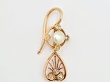 un gros plan d'un pendentif en or et perles sur fond blanc