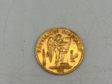 l'image d'une pièce d'or posée sur une surface blanche