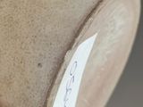 a close up of a vase with a sticker on it