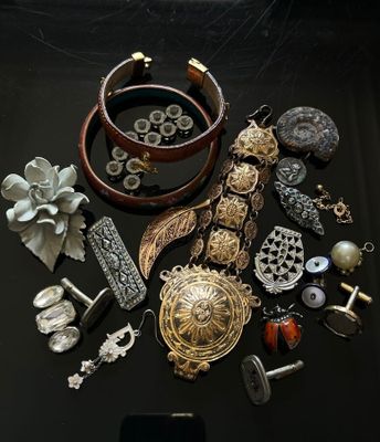 a black table with a bunch of jewelry and a cell phone