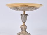 a silver and gold plate with a bird on it
