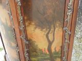 une armoire ornée d'un tableau, posée dans l'herbe