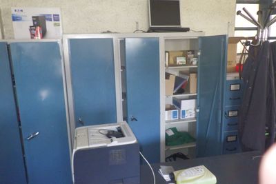 une photo d'une pièce où se trouvent de nombreux casiers bleus
