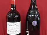 two bottles of wine sitting next to each other on a red surface