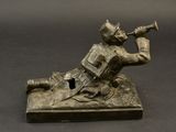 bronze statue of a man playing a trumpet on a black surface