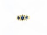 gros plan d'une bague en or avec saphirs bleus et diamants