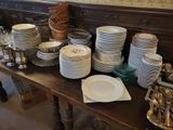 many plates and silverware on a table in a room