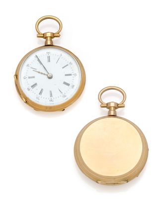 two gold pocket watches sitting next to each other on a white surface
