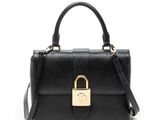 un sac à main noir muni d'un fermoir doré sur la poignée
