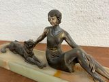 statue of a woman sitting on a marble base with a dog
