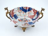 a blue and red bowl sitting on a gold stand